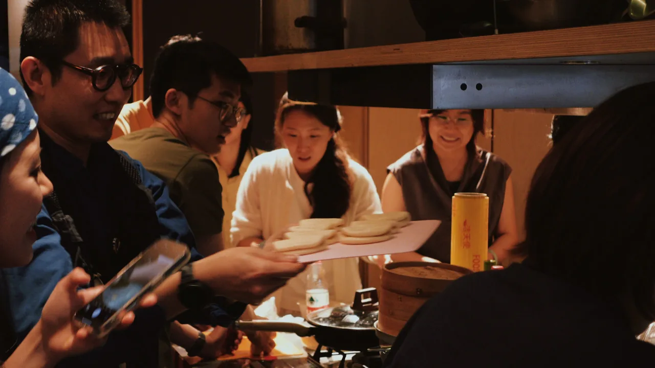 A board of folded buns passed to the steamer, from the video